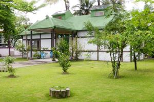 a house with a green roof and a yard with trees at Kaohsiung Meinong Rabbit Paul Homestay B&B in Meinong +22 photos