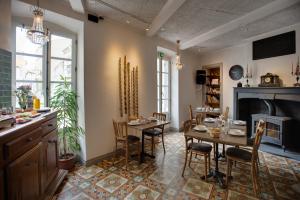 a dining room with a table and chairs and a fireplace at Rue Galilee in Marseillan