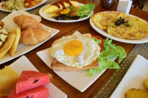 a table with plates of breakfast foods on them at Villa Sirilanna Hotel in Chiang Mai