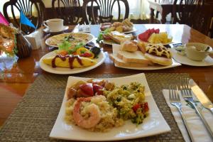 a wooden table with plates of food on it at Villa Sirilanna Hotel in Chiang Mai