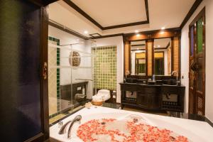 a bathroom with a large bath tub with a sink at Villa Sirilanna Hotel in Chiang Mai