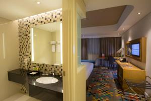 CibuburHotel Ciputra Cibubur managed by Swiss-Belhotel International的酒店客房设有带床和水槽的浴室