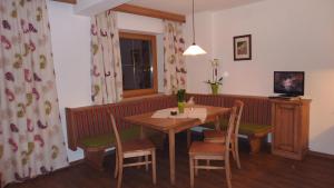 una sala da pranzo con tavolo, sedie e una finestra di Ferienhof Nogler a Zellberg