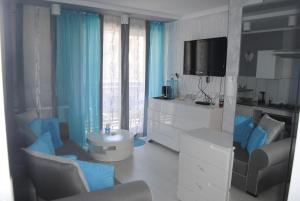 Elle comprend un salon doté de rideaux bleus et d'une télévision. dans l'établissement APARTAMENT BULWAR, à Gorzów Wielkopolski