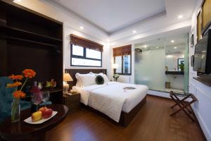 a bedroom with a bed and a table with a bowl of fruit at Hanoi Amber Hotel in Hanoi