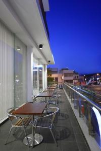 a row of tables and chairs on a balcony at night at Amaris Hotel Embong Malang - Surabaya in Surabaya