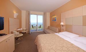 伊佐拉Hotel Mirta - San Simon Resort的带床和阳台的酒店房间