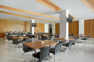 a restaurant with tables and chairs in a room at Amaris Hotel Embong Malang - Surabaya in Surabaya