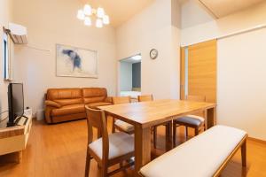 a living room with a dining room table and a couch at Ecol Beppu in Beppu