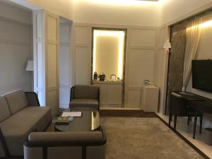 a living room with a couch and a television and a piano at Kemer Country Hotel İstanbul in Istanbul