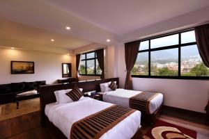 a hotel room with two beds and a large window at Park Village Resort by KGH Group in Kathmandu +69 photos