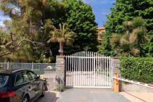 a car parked in front of a white fence at Bordighera centro molto tranquillo in Bordighera