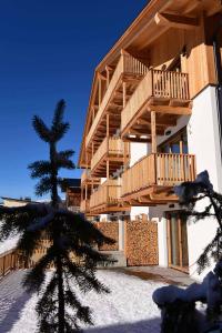 セストにあるSchäfer Apartmentsの雪中の木製バルコニー付きの建物