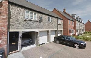 a car parked in the garage of a brick house at Liberty Locking Castle in Weston-super-Mare