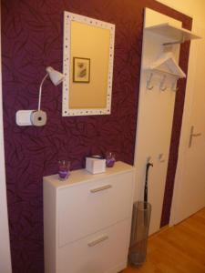 a room with a dresser and a mirror on a wall at Ferienwohnung Kutscherhof Bartels in Bispingen