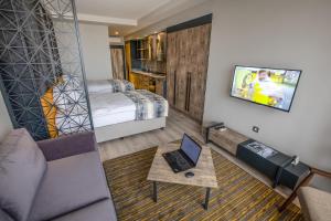 uma sala de estar com uma cama e um computador portátil sobre uma mesa em Shimall Hotel em Gaziantep