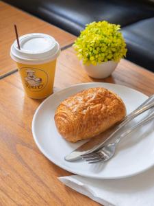 a plate with a croissant and a cup of coffee at d'primahotel Airport Jakarta Terminal 1A in Tangerang