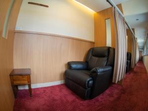 a black leather chair sitting in a room at d'primahotel Airport Jakarta Terminal 1A in Tangerang