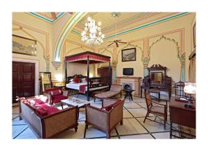 sala de estar amplia con cama y lámpara de araña. en Hotel Narain Niwas Palace, en Jaipur