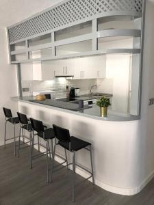 a kitchen with a counter with chairs around it at MISTRAL 17 in El Campello