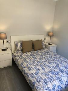 a bedroom with a bed with two nightstands and two lamps at MISTRAL 17 in El Campello