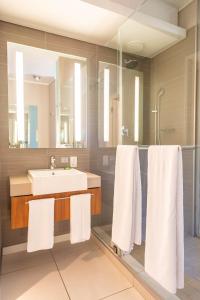 a bathroom with a white sink and white towels at aha Harbour Bridge Hotel & Suites in Cape Town