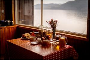 a table with a plate of food and a window at Loch Ness Lochside Hostel in Invermoriston