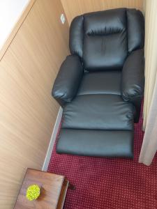 a black leather reclining chair in a room with a table at d'primahotel Airport Jakarta Terminal 1A in Tangerang