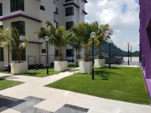 un patio con palmeras y un edificio en SkyHomestay @ The Heights Residence en Melaka