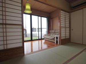 冈崎市民泊こゆり的客房设有窗户和沙发。