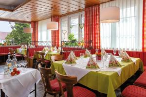 a dining room with tables and chairs and windows at Gasthof - Hotel zum Ochsen GmbH in Blaubeuren
