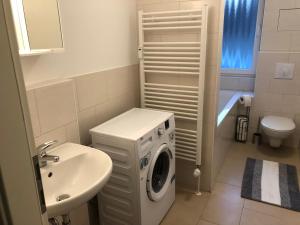 a bathroom with a washing machine and a sink at Ferienwohnung in Beelitz Heilstätten in Beelitz +67 photos