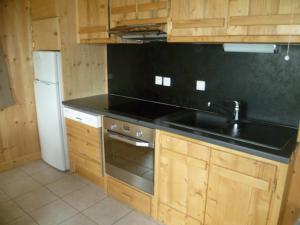 a kitchen with a black counter top and a sink at La Cour in Notre-Dame-de-Bellecombe