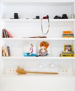 a white shelf with books and pictures on it at EDI Astoria in Santa Cruz de Tenerife