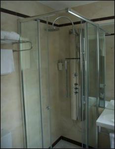 a shower with a glass door in a bathroom at Hostal Acuarela in Burgos
