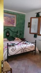 サン・ジミニャーノにあるAzienda Agricola Polveraiaの緑の壁、ベッド付きのベッドルーム1室