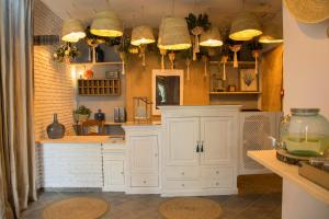 a kitchen with white cabinets and lots of lights at Hotel Mariantonia in Chiclana de la Frontera