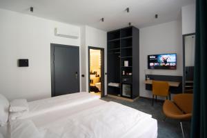 una camera con letto, scrivania e TV di Kleines Hotel a Sibiu