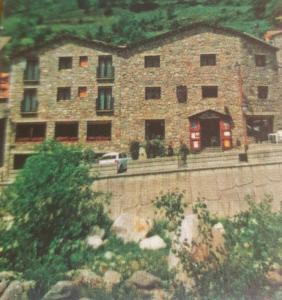 a large brick building with a car in front of it at Hostal Ter in Setcases