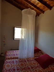 Un dormitorio con una cama con una cortina. en Monte da Clareira - Comporta Carvalhal Melides, en Grândola