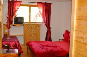 a bedroom with a red bed and a window at "0" Sterne Hotel Weisses Rössl in Leutasch/Tirol in Leutasch