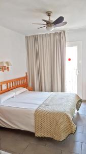 a bedroom with a bed with a ceiling fan at Hostal Isabel in Blanes