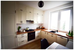 a white kitchen with white cabinets and a window at Color 24 Premium in Stalowa Wola