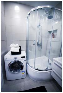eine Dusche und eine Waschmaschine im Bad in der Unterkunft Color 24 Premium in Stalowa Wola