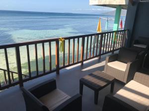 balcón con sillas y vistas a la playa en Babylon Oslob Coast Guesthouse, en Oslob