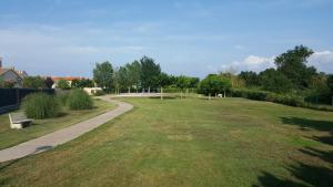 a large grassy field with a path and a park at Mas Pinell 129 in Torroella de Montgrí