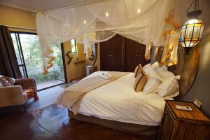 a bedroom with a large bed and a window at Leopards Rock Bush Boutique in Bela-Bela