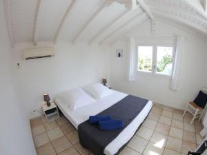 une chambre blanche avec un grand lit avec une fenêtre dans l'établissement Villa Iguanou et piscine en bord de mer proche plages marina et golf, à Saint-François 48 autres photos