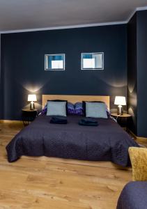 a bedroom with a large bed with blue walls at Good Time in Szczecin in Szczecin
