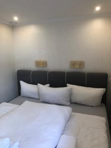 un letto con cuscini bianchi in una stanza di Wohnung Meeresbrise a Norderney